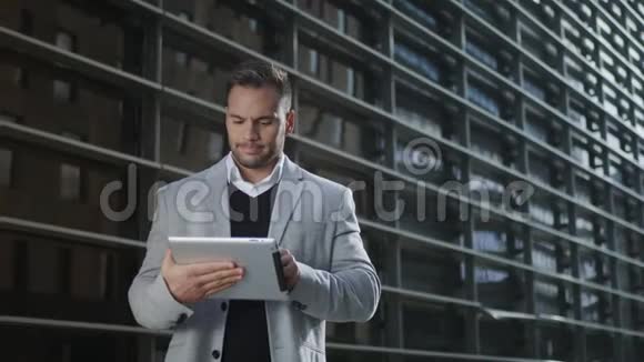 商人在街头制作数字平板电脑在外面使用触摸板的工人视频的预览图