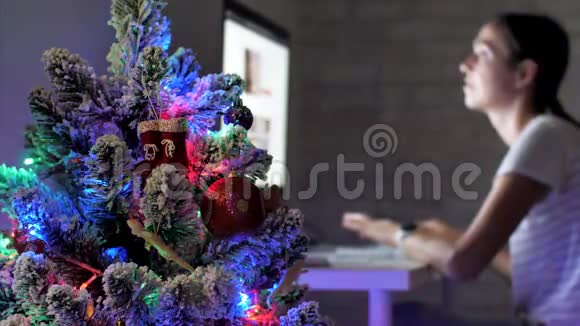 在圣诞节假期年轻女子在黑暗中使用台式电脑视频的预览图