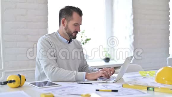 积极的年轻建筑师与笔记本电脑做大拇指办公室视频的预览图