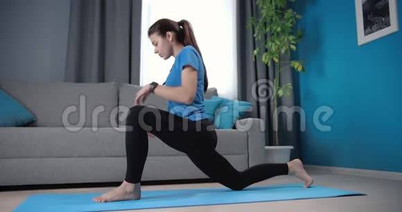 女人在蓝色瑜伽垫上伸展身体视频的预览图
