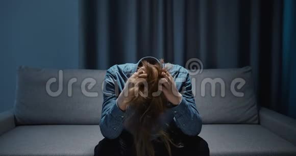 哭着沮丧的男人坐在沙发上视频的预览图