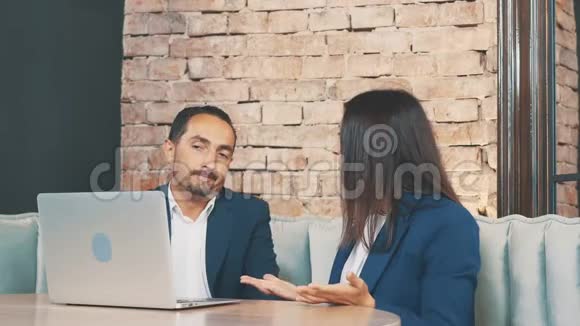 两个穿着深蓝色西装的商人正在讨论问题坐在咖啡店里复制空间视频的预览图