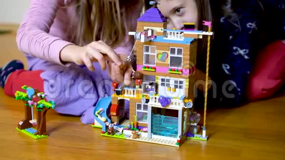 两个孩子在家里在地板上玩积木幼儿玩构造师小女孩在和警察玩视频的预览图