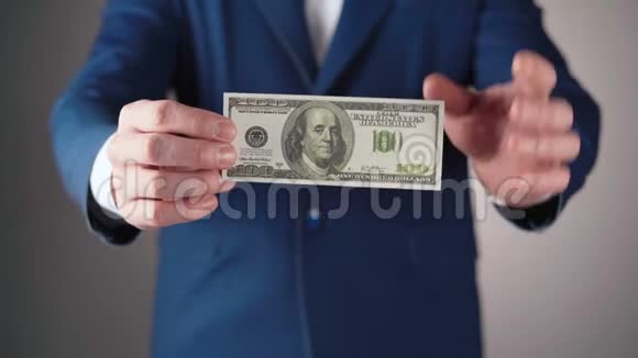 穿蓝色夹克的商人手里拿着美元视频的预览图