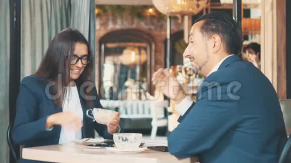 两个商务人士握手他们吃商务午餐在餐馆或咖啡店里的女人和男人视频的预览图