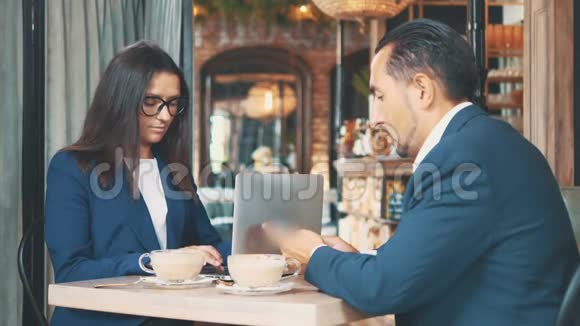 两个商人吃商务午餐餐馆或咖啡店里的男人在喝咖啡而女人是视频的预览图