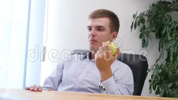 年轻的商人正在办公室里吃苹果快关门复制空间4K视频的预览图