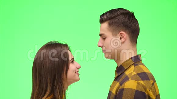 迷人的男女正在分享亲密的时刻在绿色的背景上温柔地亲吻快关门复制空间4K视频的预览图