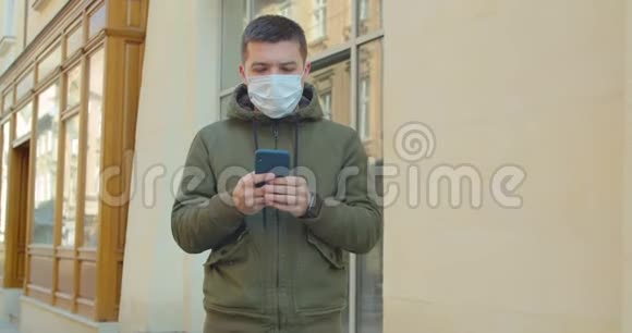 戴防护面罩的人使用电话COVID19冠状病毒感染一个白种人的医疗画像视频的预览图