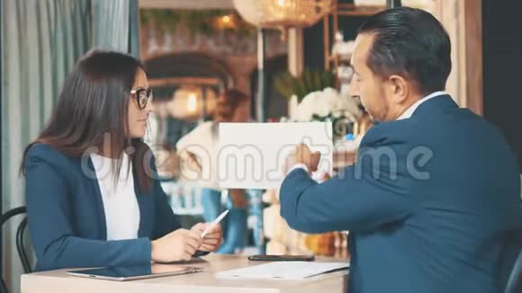 两个商人在一家咖啡馆工作他们正在讨论和准备合同快关门复制空间视频的预览图