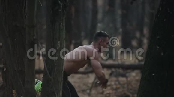 孤独的肌肉运动员以赤裸的躯干在树林间奔跑一张电影照秋天的叶子视频的预览图