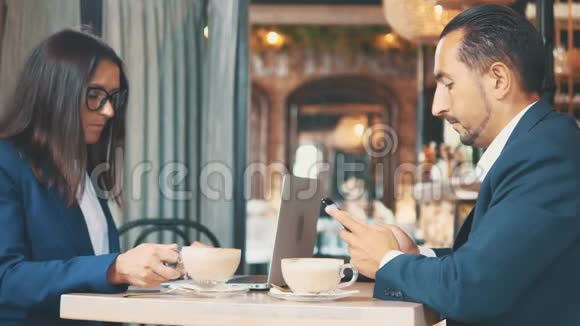 两个商人吃商务午餐在一家餐馆或咖啡店里女人和男人正在搅拌和视频的预览图