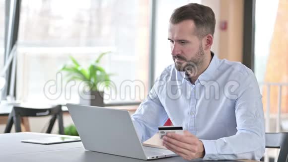 青年男子在办公室笔记本电脑网上缴费视频的预览图