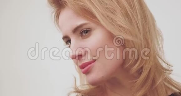 一位带着绿色眼睛的美丽金发白种人女子的特写肖像视频的预览图