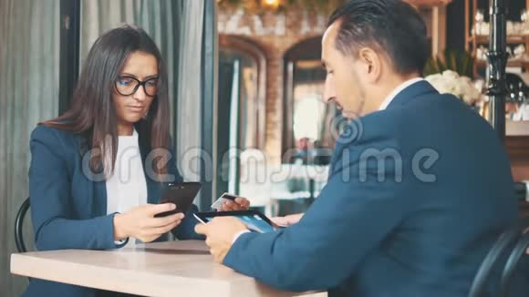 两个穿深蓝色西装的商人正在工作人类正在研究平板电脑女人在网上买东西的时候视频的预览图