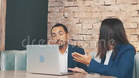 两个穿着深蓝色西装的商人正在讨论问题坐在咖啡店里复制空间视频的预览图
