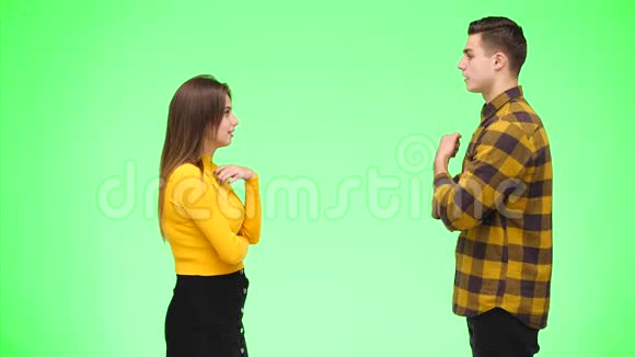 年轻的女人正在和年轻的男人争论在绿色的背景下被孤立复制空间4K视频的预览图