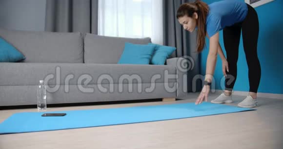 强壮的黑发女子站在瑜伽垫的木板位置视频的预览图