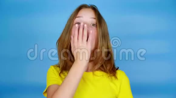 穿黄色T恤的少女非常惊讶用手捂住了嘴视频的预览图