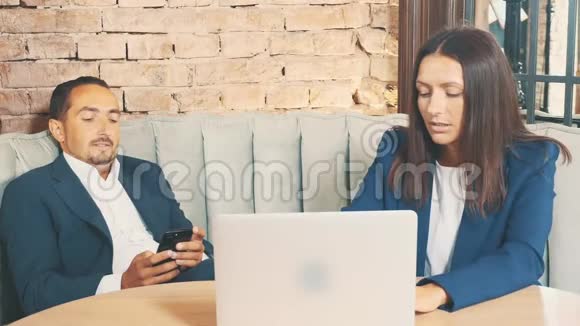 两个商人在一家咖啡馆工作人躺着正在打电话女人求他开始工作关门视频的预览图