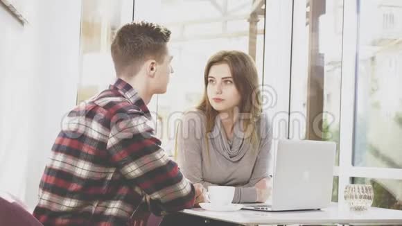 可爱的女孩坐在咖啡馆的桌子旁她正在和男朋友交流专心的一对关门视频的预览图