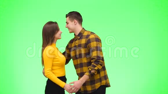 年轻浪漫的情侣在绿色背景下跳舞快关门复制空间4K视频的预览图