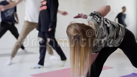 一群运动青年在室内练习瑜伽前景看好的金发美女视频的预览图