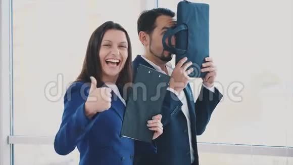 快乐的工作人员在模糊的光线背景下微笑着跳舞做着脸快关门动画4K视频的预览图