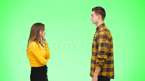 年轻的女人正在和年轻的男人争论在绿色的背景下被孤立复制空间4K视频的预览图