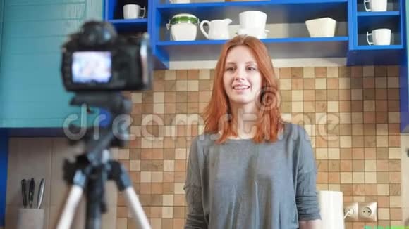 食品博客女孩影响者正在厨房录制视频或播客使生活方式博客vlog显示心脏视频的预览图