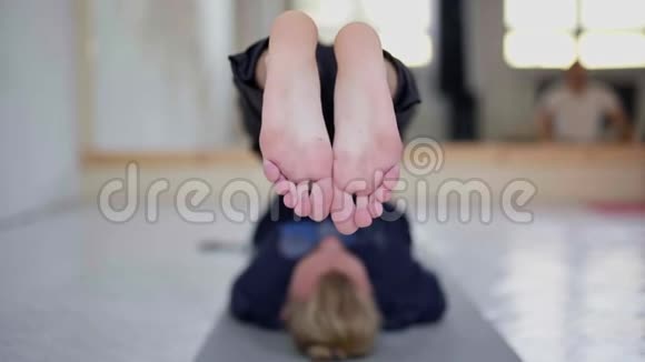 慢动作的年轻人无法辨认的人在轻瑜伽课上练习瑜伽视频的预览图