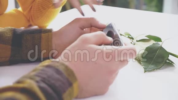 可爱的女孩坐在咖啡馆的桌子旁她正在和男朋友交流男朋友给她看一些东西视频的预览图