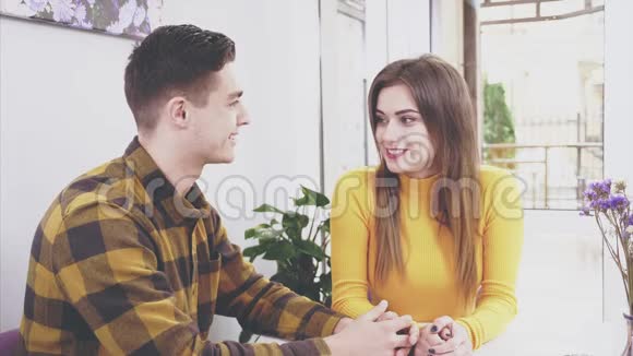 有爱心的男人和一个谦虚的女孩正在阁楼咖啡馆里交谈在咖啡馆里的浪漫约会男人和女人坐在桌子旁视频的预览图