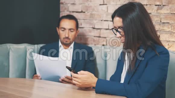 两个商人在一家咖啡馆工作人类正在用心学习文件女人在滚动快关门复制空间视频的预览图