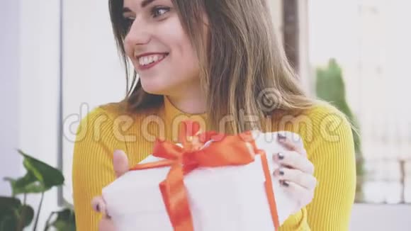 可爱的女孩拿着一个带红色丝带的礼物盒行动动画4K视频的预览图