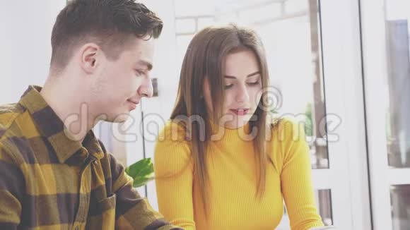 可爱的女孩坐在咖啡馆的桌子旁他们在手机上互相展示一些东西快关门副本视频的预览图