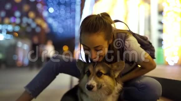 可爱的年轻女人在户外抚摸和拥抱可爱的科吉狗视频的预览图