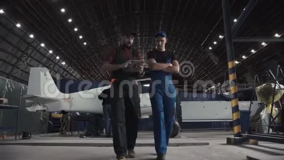 两名飞行工程师穿过一个机库视频的预览图