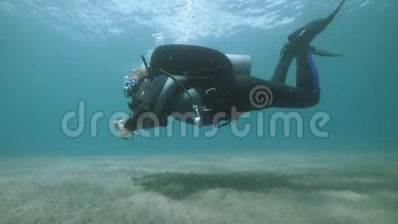 雄性水肺潜水员在海洋中的深水中游泳视频的预览图