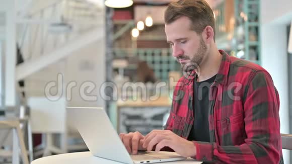 失望青年拿着手提电脑倒在咖啡厅视频的预览图
