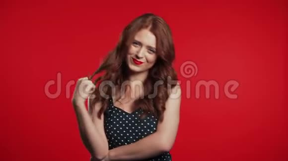 红发美女站在摄影棚的背景上微笑着调情视频的预览图