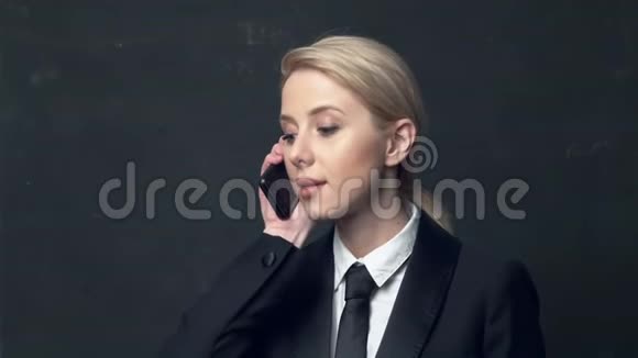 女商人穿着经典的西装打着领带在手机上聊天视频的预览图