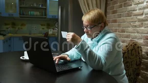 老年妇女在线购买使用笔记本电脑和塑料卡视频的预览图