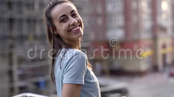 快乐微笑的年轻女子穿着休闲装在城市街道背景上摆姿势视频的预览图