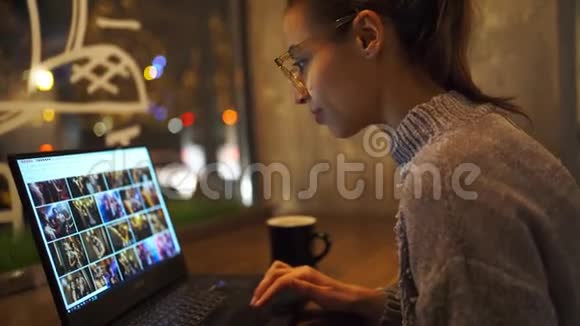 在咖啡馆晚上工作的妇女的特写照片使用电脑触摸屏看监视器视频的预览图