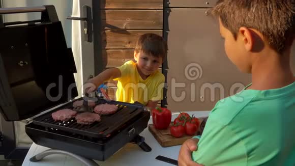 男孩子们在烤架上做菜视频的预览图