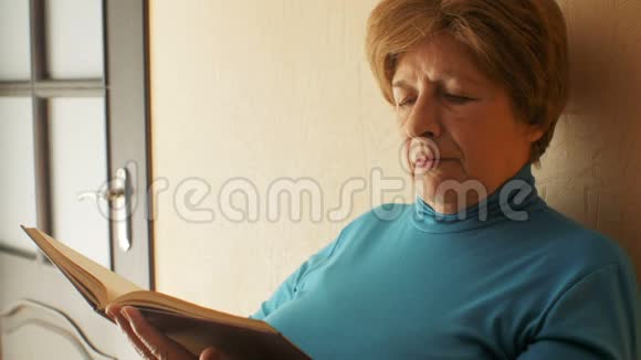 可爱的奶奶的脸晚上在家看书老人的生活方式奶奶的休闲视频的预览图