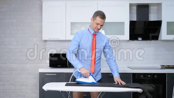 垂直射击穿领带熨衣裤的帅哥他家的厨房视频的预览图