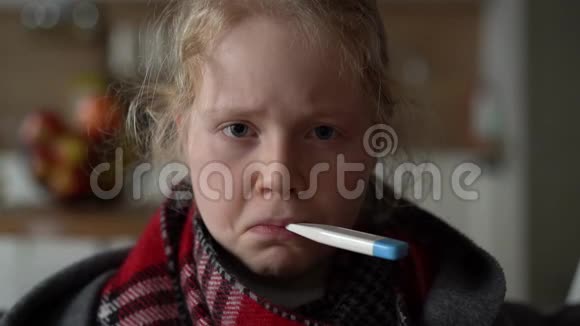 冷白种人女孩在家一个穿着围巾和格子的生病孩子的滑稽肖像沙发上有一个温度计视频的预览图