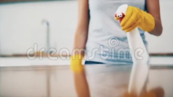 戴着黄色橡胶手套的女人正在厨房用除脂剂喷雾和布清洁烹饪面板作物复制空间视频的预览图